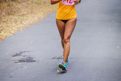 Low section of woman walking on road