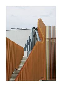 Low angle view of metal cladding against clear sky