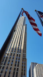 Low angle view of skyscrapers against blue sky