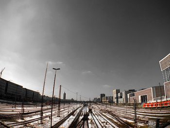 Train on railroad tracks in city against sky