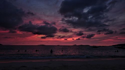 Scenic view of beach against sky at sunset