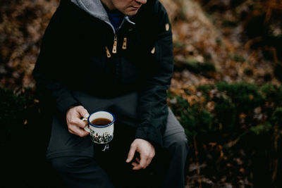 Midsection of man holding coffee