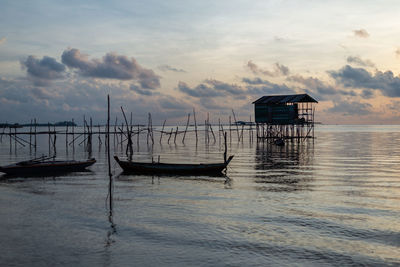 Ship moored in sea against sky during sunset