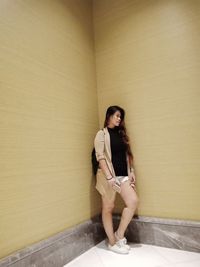 Portrait of woman against wall