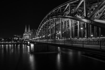 Illuminated bridge over river at night