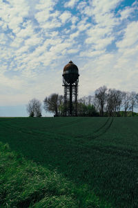 Traditional windmill on field against sky