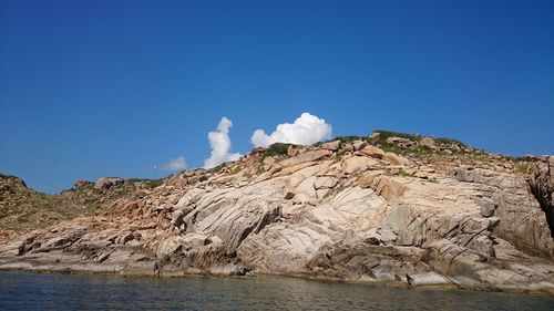 Sea and rock formations against blue sky