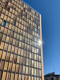 Low angle view of modern building against clear blue sky