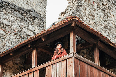Low angle view of woman standing against building