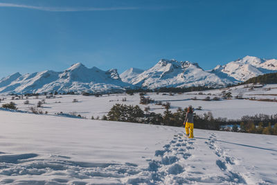 A full-body shot of an unrecognizable young caucasian woman walking in the french alps mountains