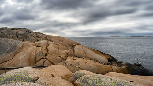 Rock formations by sea against sky