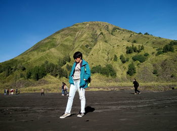 People against mountain at beach