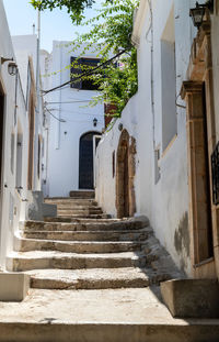 Narrow street with stairs and white houses in lindos on greek island rhodes