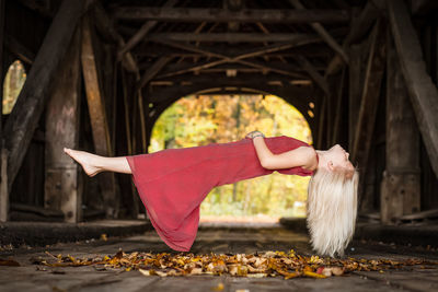 Full length of woman levitating under bridge