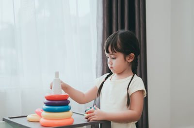 Girl playing with multi colored toys at home