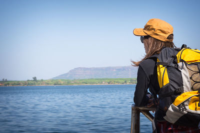 Rear view of person looking at sea against sky