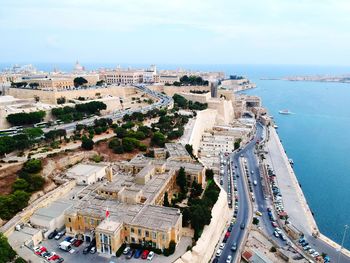 High angle view of city by sea against sky