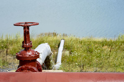 Close-up of fire hydrant on field against wall