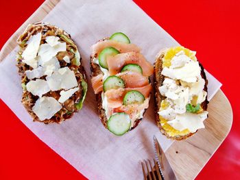 Directly above shot of salmon and vegetables on toasted breads