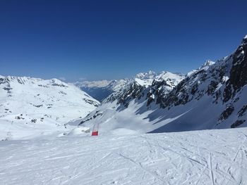 Scenic view of snowcapped mountains against clear blue sky