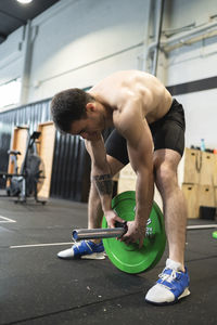 Sportsman lifting barbell in health club