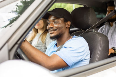 Portrait of smiling young man sitting in car