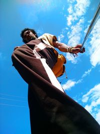 Low angle view of man holding a selfie-stick