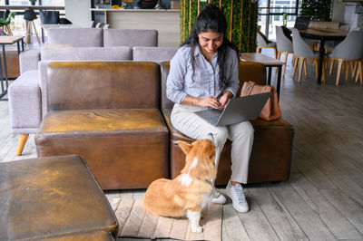 Portrait of young woman sitting on sofa at home