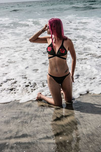 Full length of young woman standing on beach