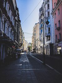 Empty road amidst buildings in city