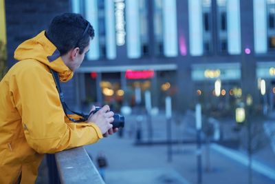 Side view of man looking at city street