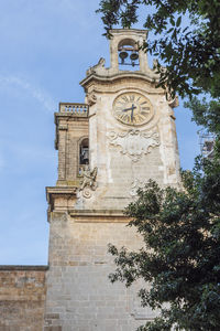 Low angle view of clock tower against sky