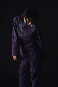 Young woman standing against black background