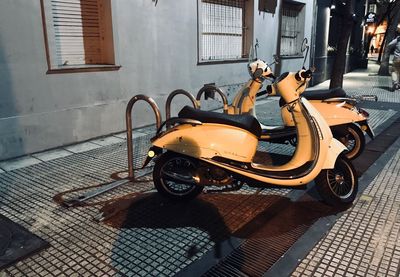 Motor scooter on footpath by street in city