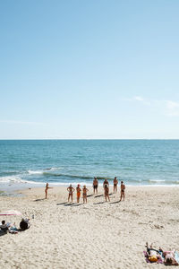 Group of people on beach against sky