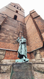 Low angle view of woman standing against building