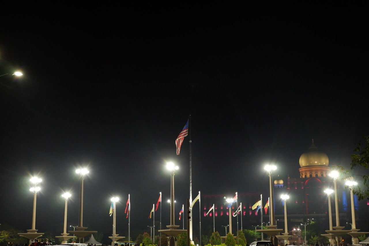 ILLUMINATED STREET LIGHTS AGAINST STAR FIELD AT NIGHT