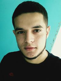 Portrait of young man against blue background