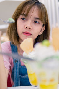 Young woman eating ice cream in restaurant