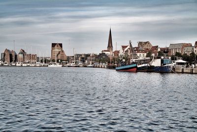 Boats in river with buildings in background