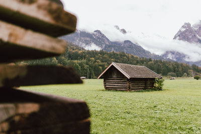 House on field against mountain