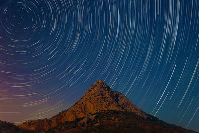 Low angle view of star trails in sky at night