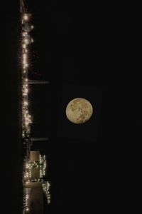 Low angle view of illuminated moon in sky at night