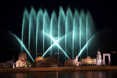 Illuminated fountain building against sky at night