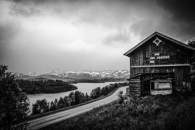 Panoramic view of road by building and houses against sky