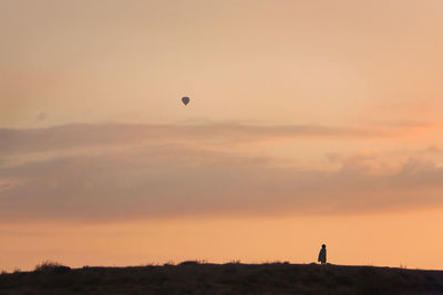 Silhouette of hot air balloon against sky at sunset