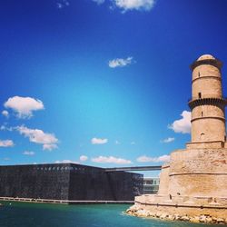 Built structures against blue sky and clouds