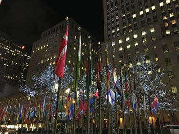 Low angle view of illuminated flags against sky at night