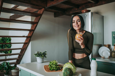 Portrait of woman holding food on table