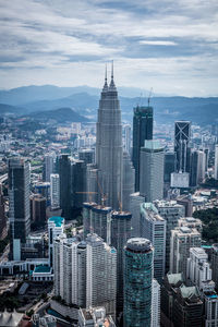 Skyscrapers in city against cloudy sky